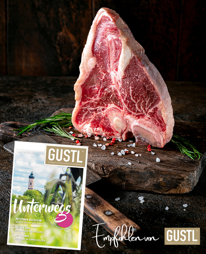 Large raw t-bone steak on a wooden board with seasonings and pepper. Florentine or Porterhouse steak with a meat cleaver